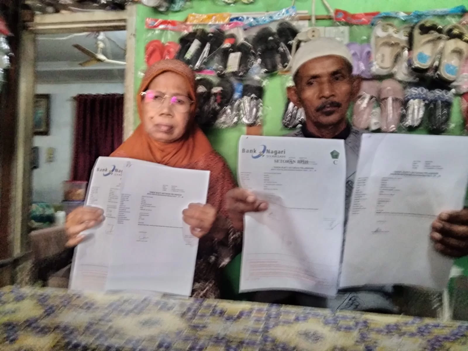 Anwar Chan bersama istri memperlihatkan surat pemberangkatan haji.