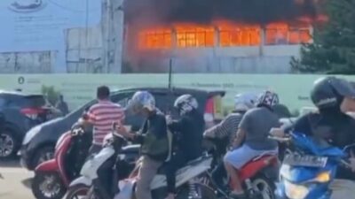 Kobaran api yang membakar gedung menjadi tontonan bagi pengendara yang kebetulan lewat di lokasi kebakaran.
