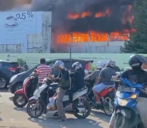 Kobaran api yang membakar gedung menjadi tontonan bagi pengendara yang kebetulan lewat di lokasi kebakaran.