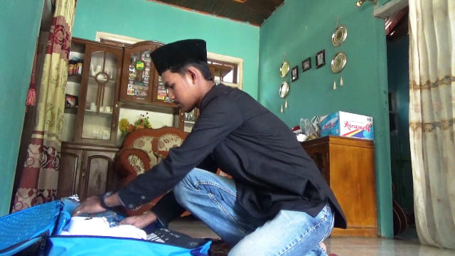 Naufal saat mengemasi barang bawaan jelang berangkat ke Tanah Suci.