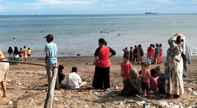 Masyarakat menyaksikan prosesi evaluasi jenazah korban Terguling Ombak di Pantai Air Bangis.