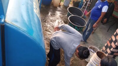 Petugas Perumda AM Kota Padang menyalurkan air tangki kepada masyarakat yang membutuhkan di Kota Padang.