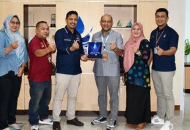 Dirut Perumda AM Kota Padang, Hendra Pebrizal (tengah) berfoto dengan jajaran petinggi KI Sumbar.