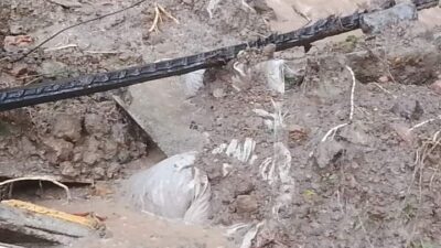 Jasad jenazah terbungkus kafan ke luar dari liang lahat lantaran Lingsir yang terjadi di pandam perkuburan warga Koto Anau di Seberang Palinggam.