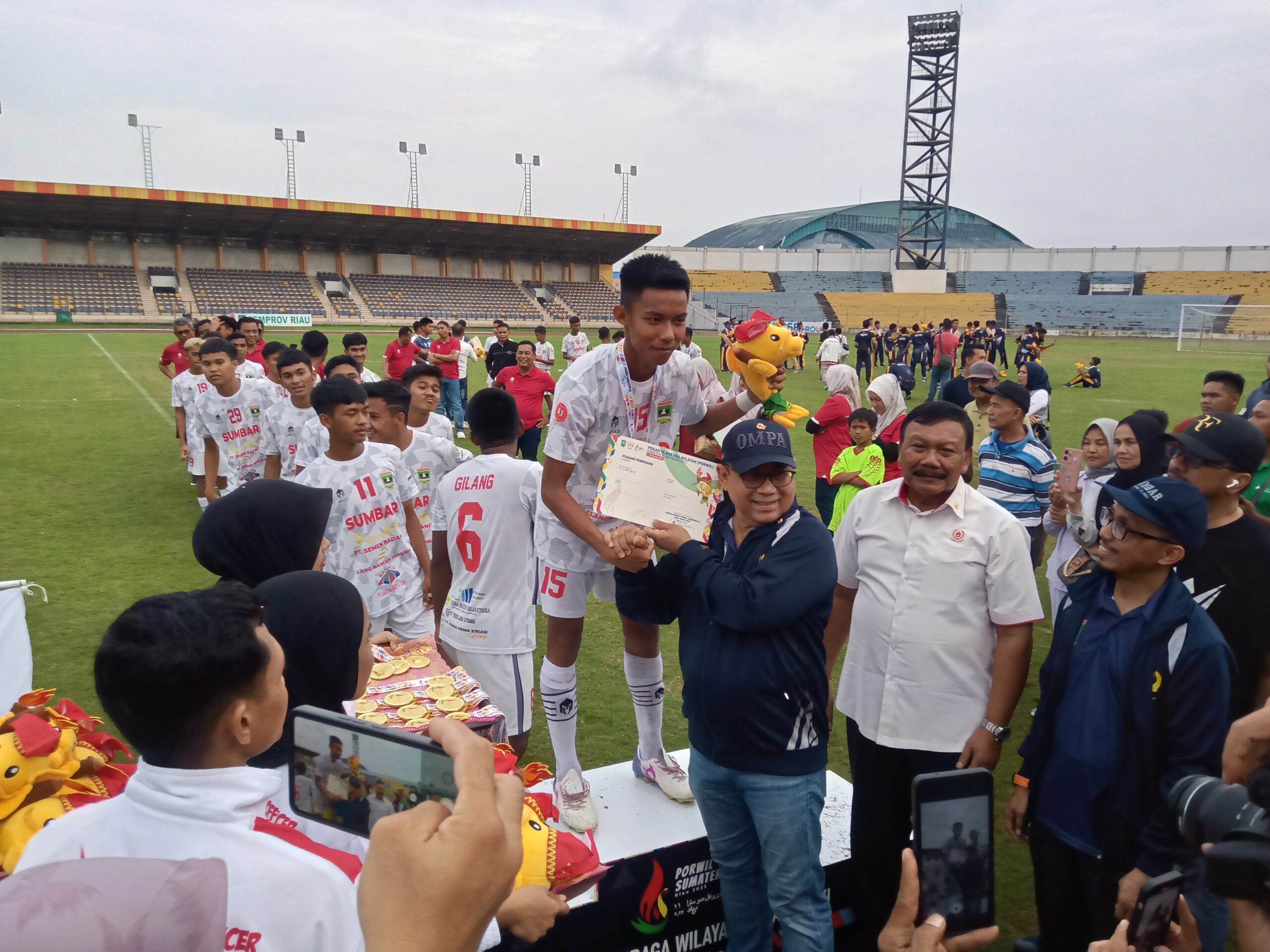 Ketua KONI Sumbar, Ir Ronny Pahlawan mengalungkan medali pada pemain Sumbar yang sukses meraih medali emas Sepakbola Porwil 2023.