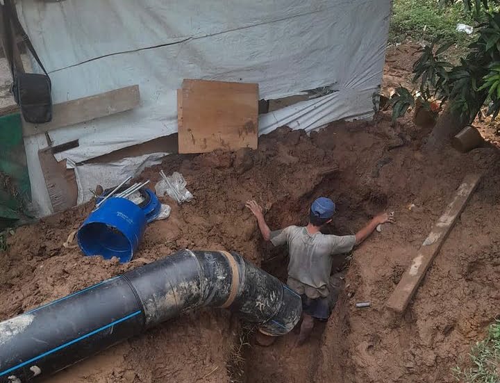 Seorang petugas melakukan pekerjaan perbaikan pipa Perumda AM Padang.