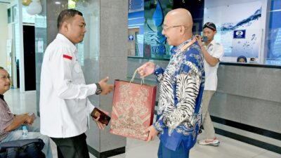 Direktur Utama Perumda AM Padang, Hendra Pebrizal memberikan sovenir kepada pelanggan dalam rangka Harpelnas 224.