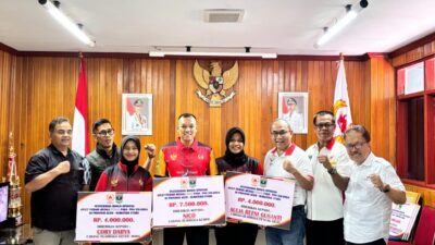 Ketua KONI Sumbar Ronny Pahlawan saat menyerahkan bonus spontan kepada perwakilan atlet